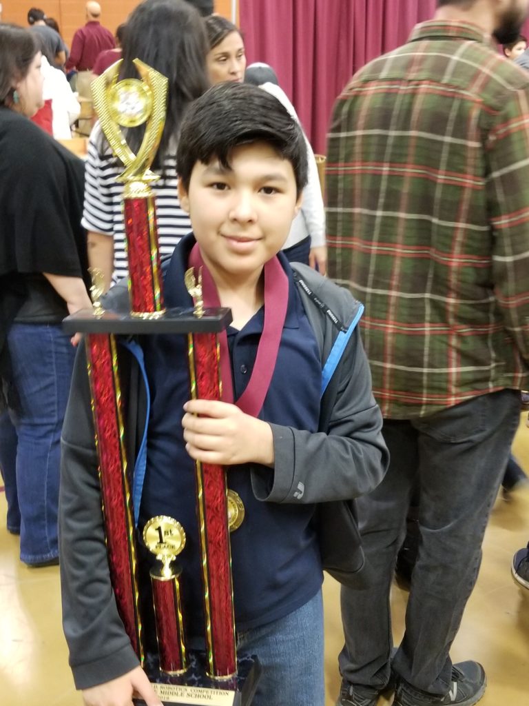 Kaeden with their team's 1st Place Robotics Trophy